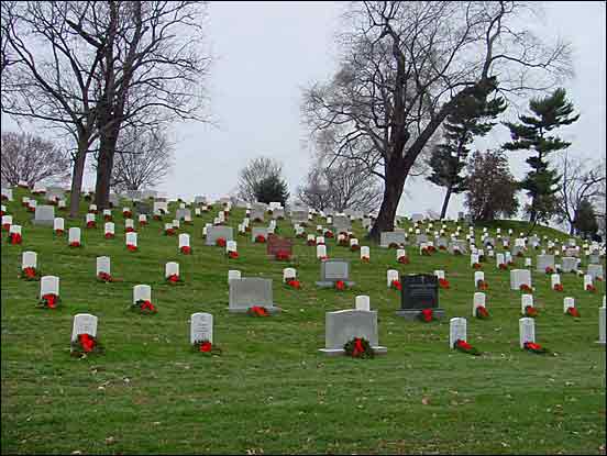 Red-ribboned wreaths on a hillside of graves in Section 8 mark the holiday season at Arlington National Cemetery.